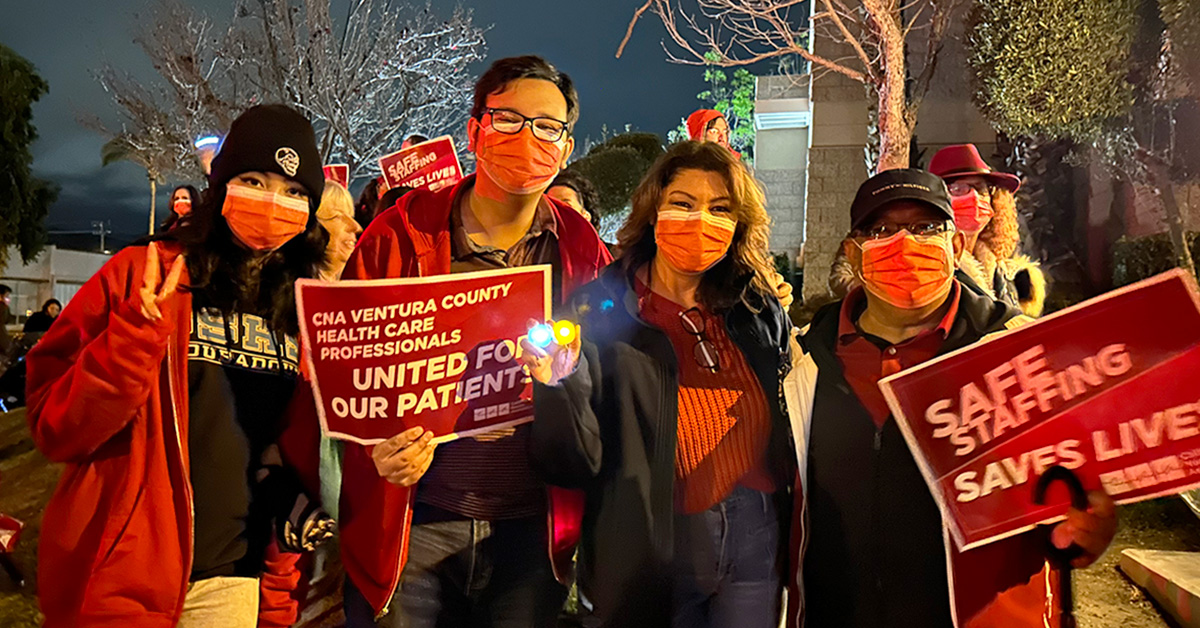 Four nurses standing outside, one holds sign "CNA Ventura County health care proffessionals united for our patients"