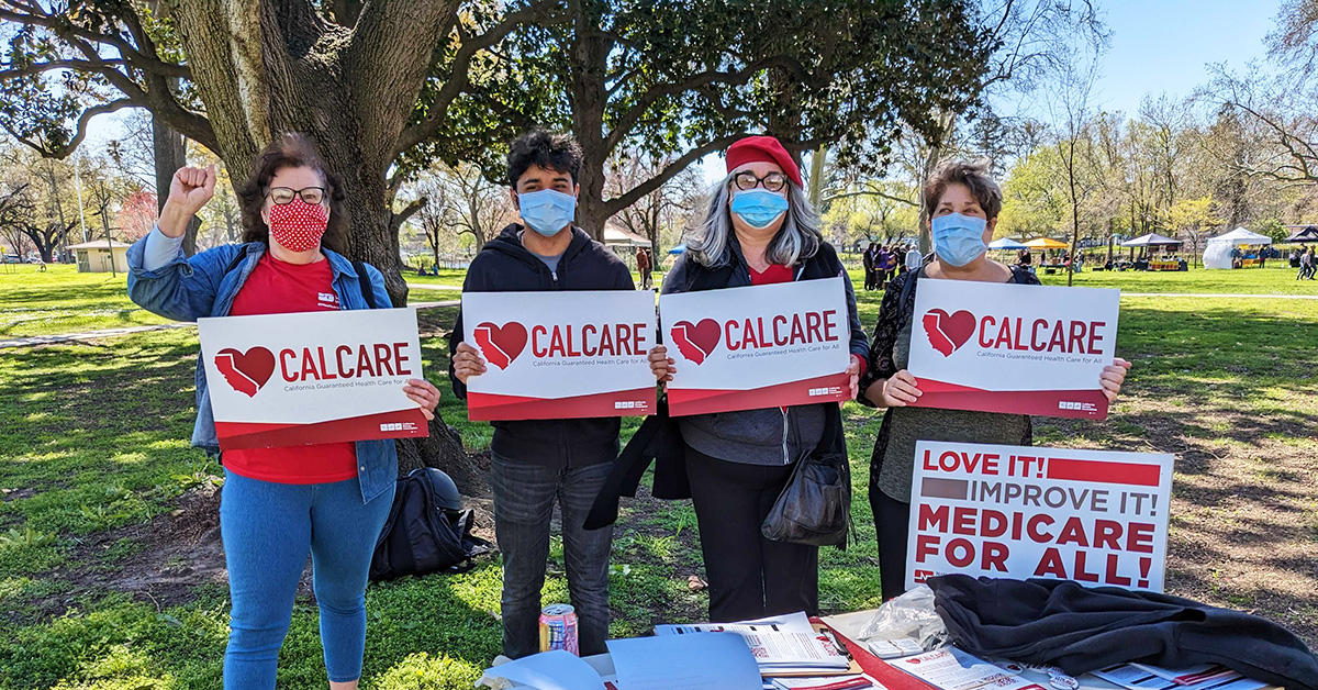 Group of four people all holding CalCare signs